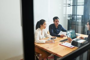 Young people sitting at the table and have a business consultation with businessman who using laptop computer at office