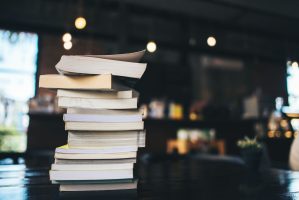 Composition with stack of books on table in cafe